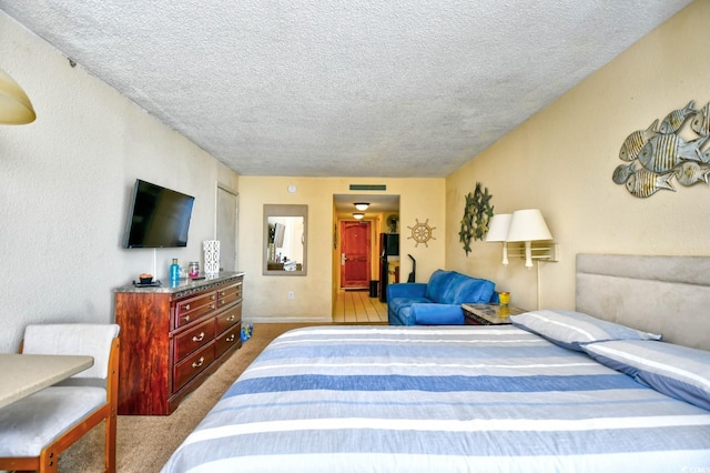 bedroom with a textured ceiling, carpet flooring, and visible vents