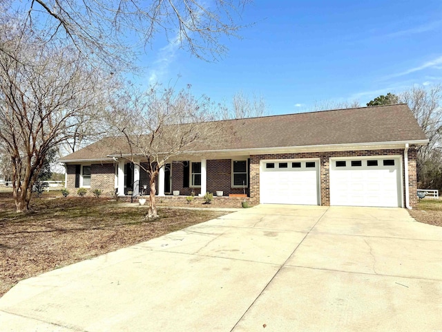 ranch-style house featuring a garage, driveway, brick siding, and roof with shingles