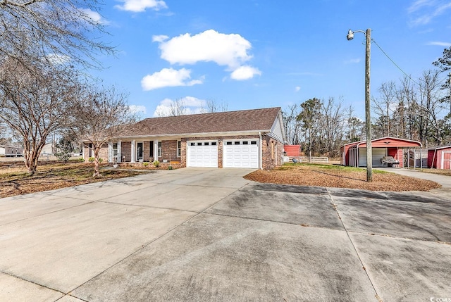 view of front facade featuring a garage, an outbuilding, concrete driveway, and brick siding