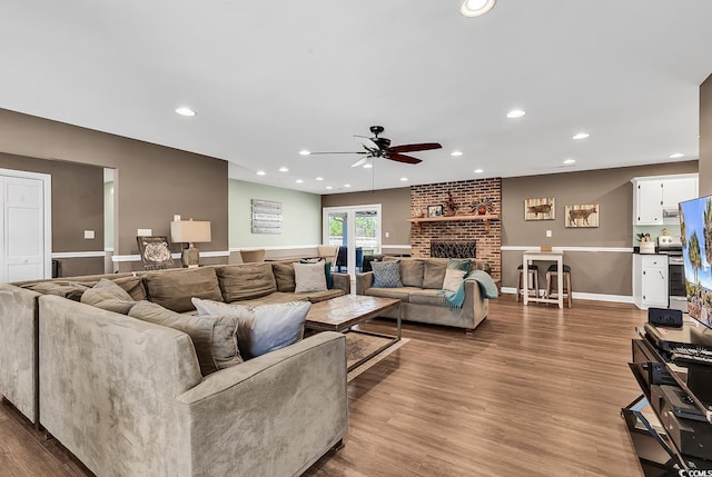 living room with ceiling fan, recessed lighting, wood finished floors, baseboards, and a brick fireplace