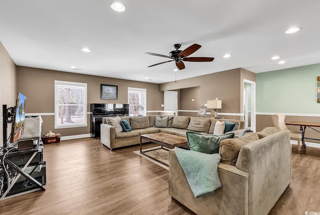 living area featuring baseboards, ceiling fan, wood finished floors, and recessed lighting