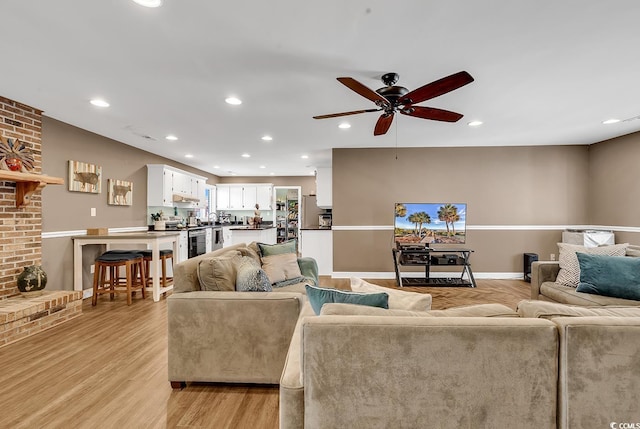 living area featuring recessed lighting, ceiling fan, light wood-style flooring, and baseboards