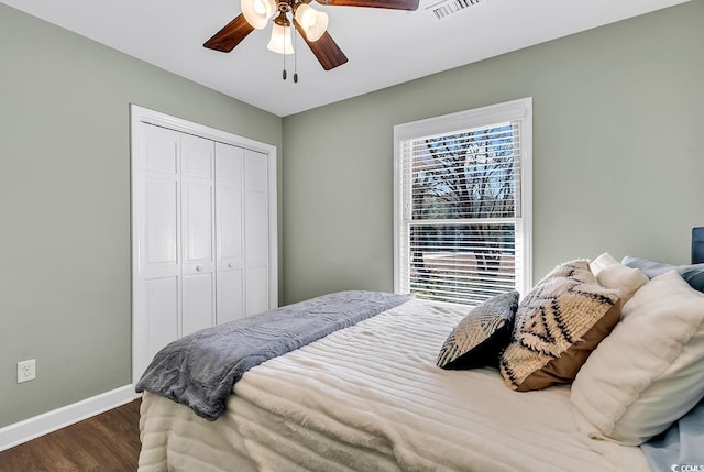 bedroom with dark wood-type flooring, visible vents, baseboards, and multiple windows