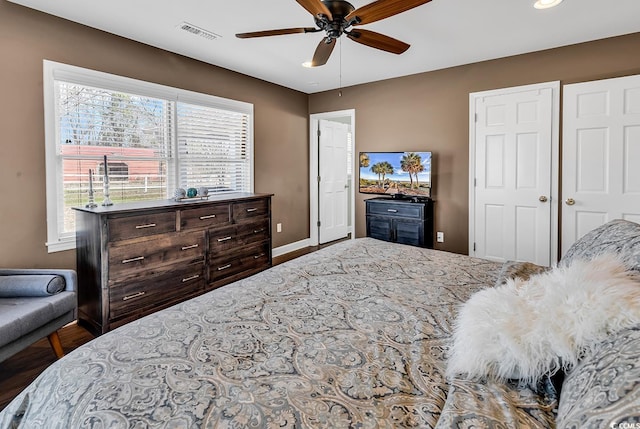 bedroom with baseboards, visible vents, and a ceiling fan