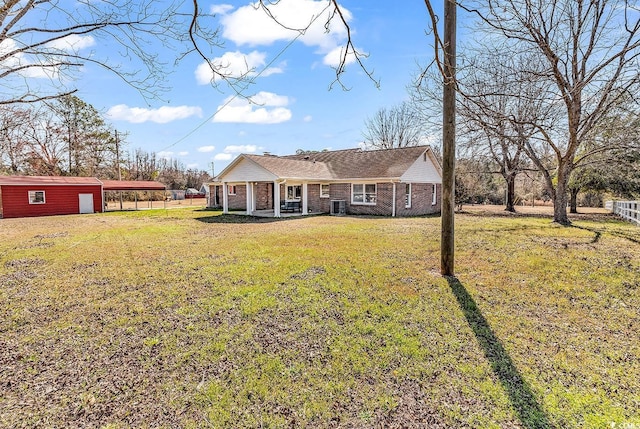 view of front facade with a carport, a front yard, brick siding, and fence