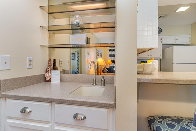 interior details featuring visible vents, freestanding refrigerator, and a sink