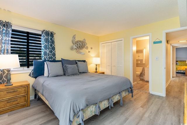 bedroom with wood finished floors, a closet, and baseboards