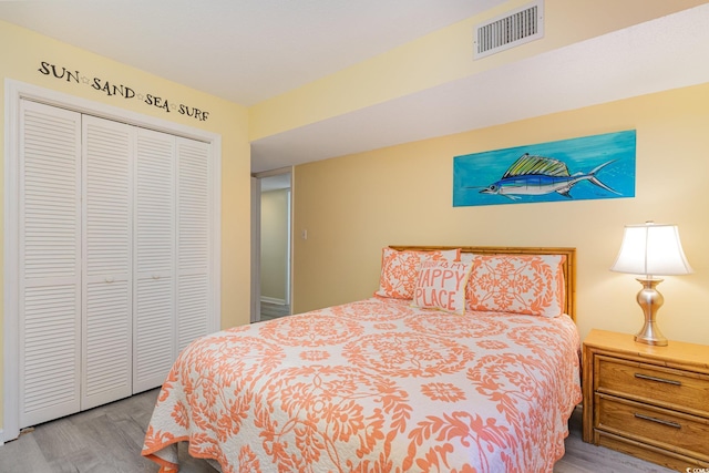 bedroom featuring a closet, visible vents, and wood finished floors