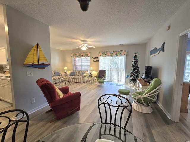 living room with a ceiling fan and wood finished floors