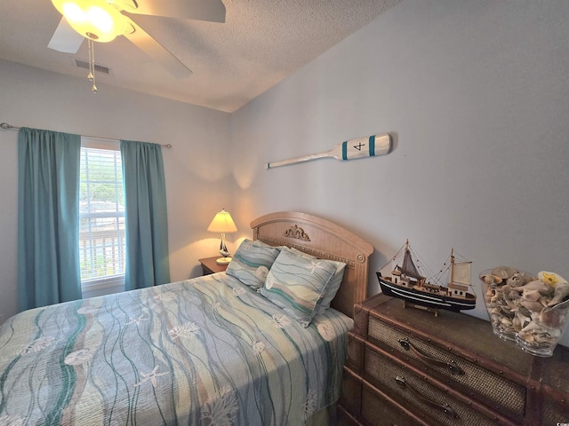 bedroom featuring light wood finished floors, visible vents, and a ceiling fan