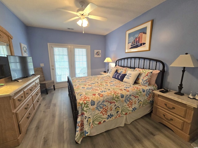 bedroom featuring light wood-type flooring, visible vents, and a ceiling fan