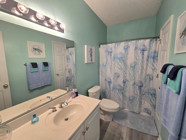 full bathroom featuring a textured ceiling, curtained shower, toilet, wood finished floors, and vanity