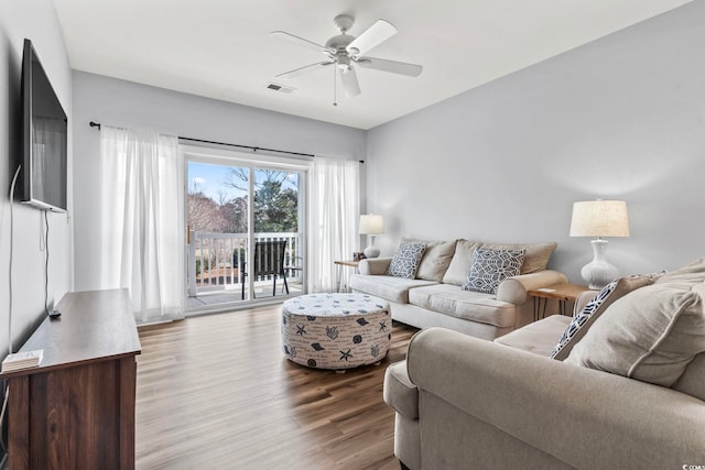 living area featuring visible vents, ceiling fan, and wood finished floors