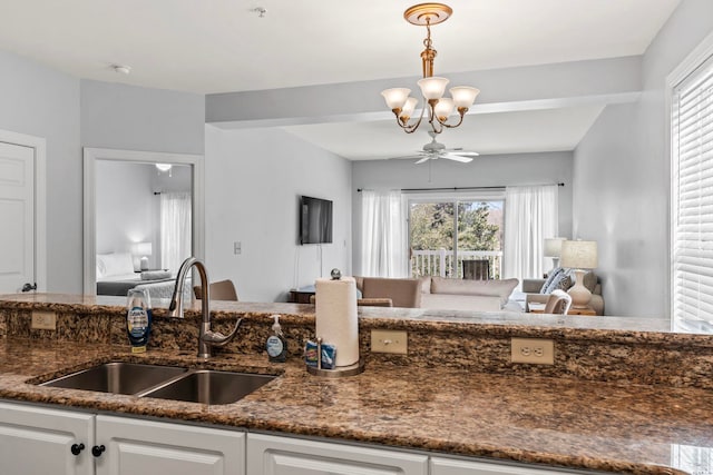 kitchen with a sink, white cabinetry, plenty of natural light, and a chandelier