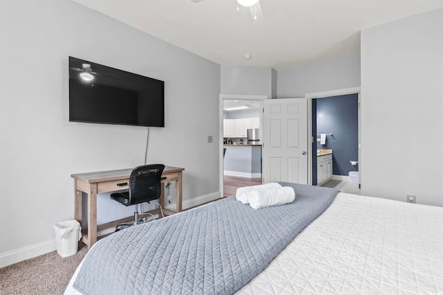 bedroom with ensuite bathroom, baseboards, ceiling fan, stainless steel refrigerator, and carpet flooring