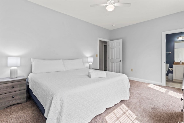 carpeted bedroom with baseboards, a ceiling fan, and ensuite bath