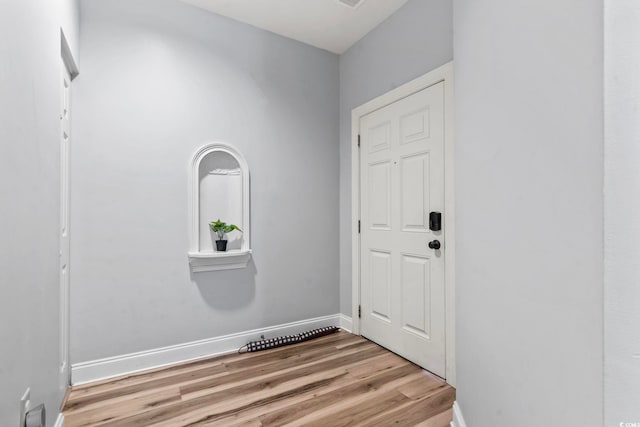 doorway with wood finished floors and baseboards