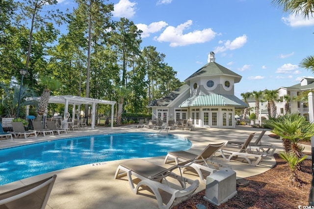 pool with french doors, a patio, and a pergola