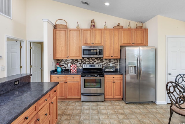 286 Bonnie Bridge Cir, Myrtle Beach, SC 29579 - kitchen featuring appliances with stainless steel finishes, lofted ceiling, dark countertops, decorative backsplash, and recessed lighting