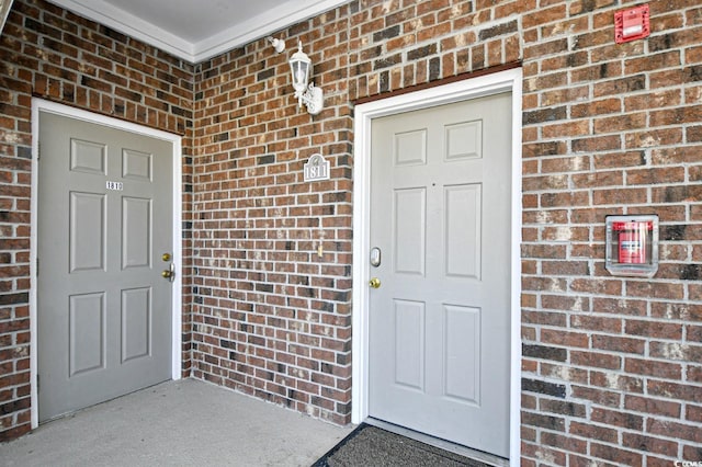 view of exterior entry featuring brick siding