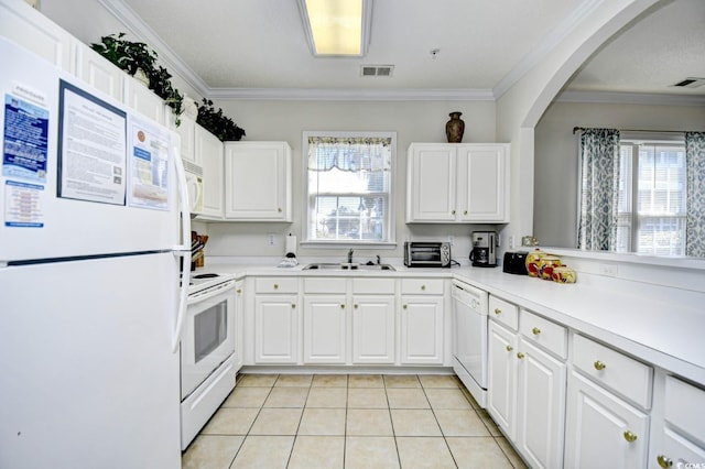 kitchen with white appliances, crown molding, visible vents, and a sink