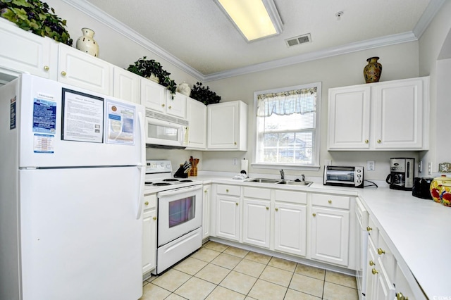 kitchen featuring crown molding, white appliances, visible vents, and a sink