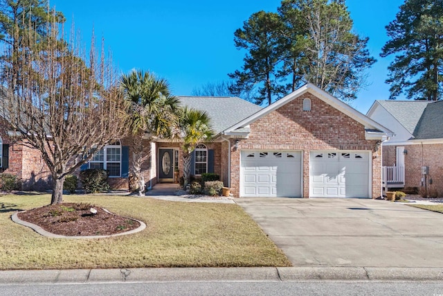 view of front of house featuring brick siding, a shingled roof, an attached garage, a front yard, and driveway