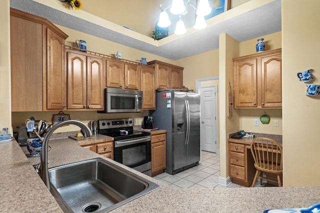 kitchen with light tile patterned floors, stainless steel appliances, a sink, and light countertops