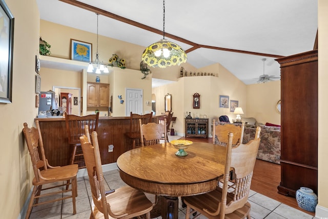 dining space with light tile patterned floors, vaulted ceiling, and a ceiling fan