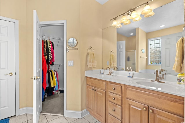 full bath with double vanity, tile patterned flooring, a sink, and a shower stall