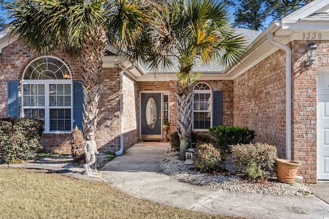 entrance to property featuring brick siding