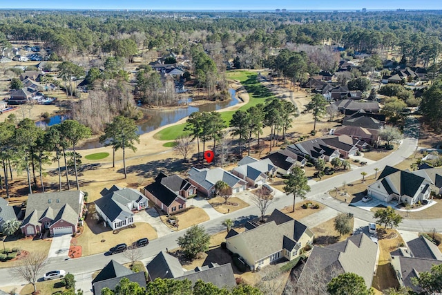 drone / aerial view featuring a forest view, a water view, and a residential view