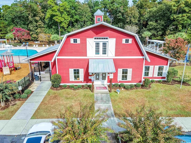 4517 Planters Row Way, Myrtle Beach, SC 29579 - view of front of home featuring fence, a front yard, a gambrel roof, and french doors