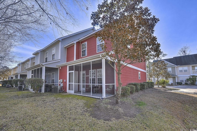 back of property featuring a lawn and a sunroom