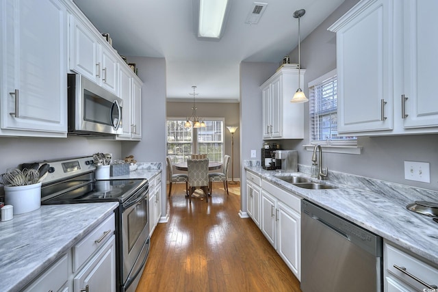 kitchen featuring stainless steel appliances, a sink, visible vents, white cabinetry, and dark wood-style floors