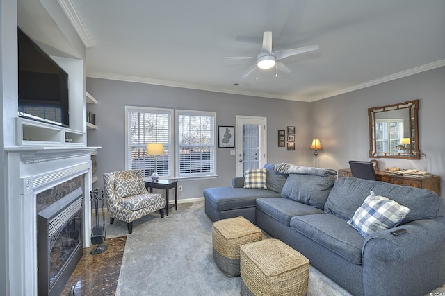 living area with ornamental molding, a fireplace, a ceiling fan, and baseboards