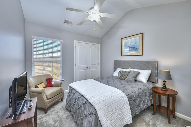 carpeted bedroom with baseboards, visible vents, lofted ceiling, ceiling fan, and a closet