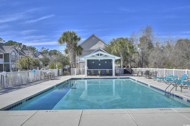 pool with a ceiling fan, fence, and a patio