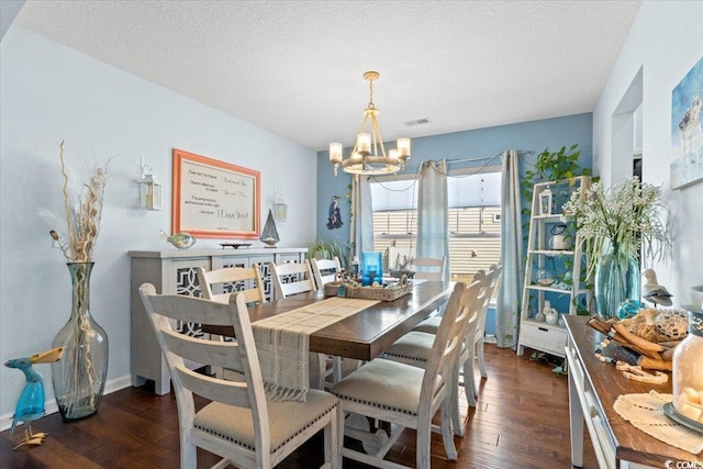 dining area with visible vents, a notable chandelier, a textured ceiling, and hardwood / wood-style floors