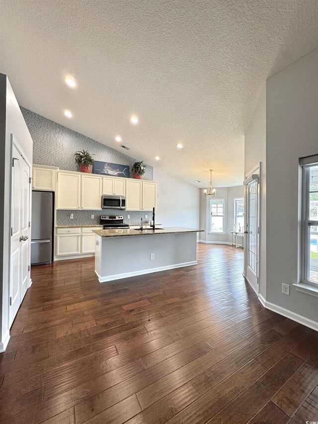 556 Cedar Lakes Dr, Little River, SC 29566 - kitchen with appliances with stainless steel finishes, a textured ceiling, dark wood-type flooring, a center island with sink, and recessed lighting