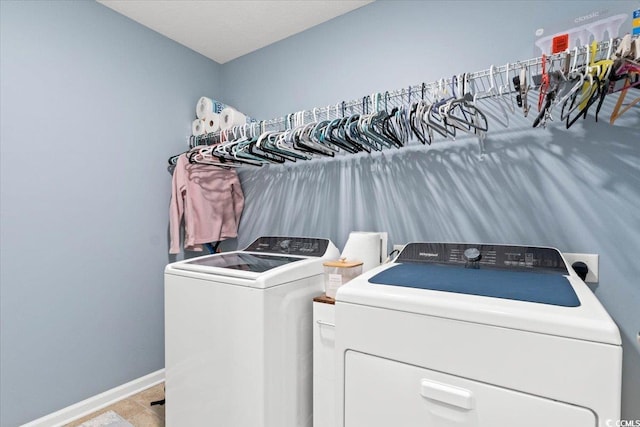 washroom with laundry area, separate washer and dryer, and baseboards