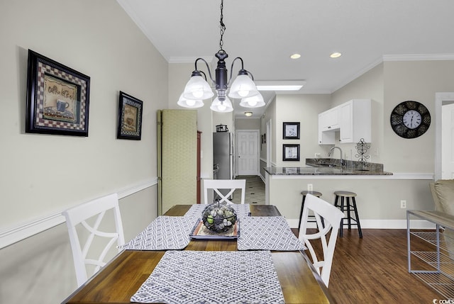 dining space with baseboards, dark wood-style floors, a notable chandelier, ornamental molding, and recessed lighting