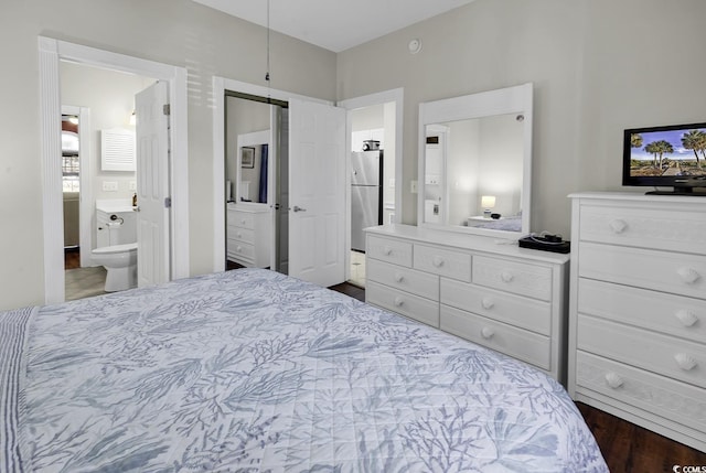 bedroom featuring ensuite bathroom and freestanding refrigerator