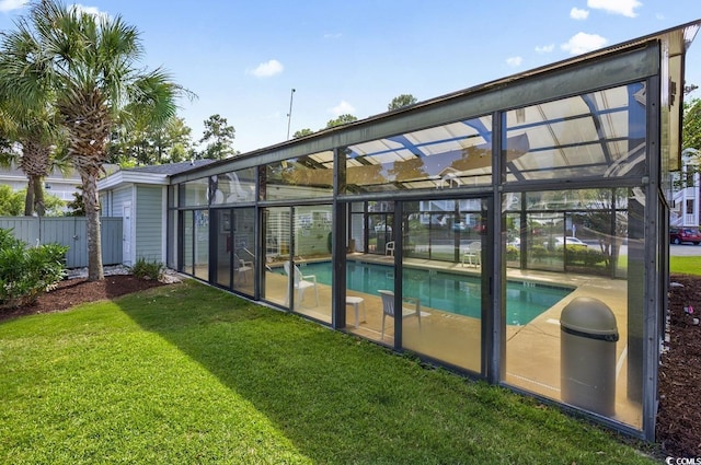 view of pool with a yard, fence, a fenced in pool, and glass enclosure