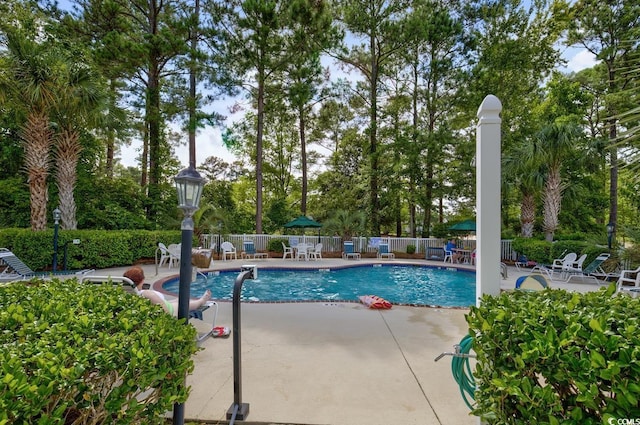 pool with a patio and fence