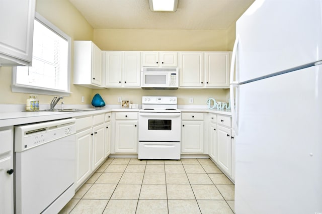 kitchen with light countertops, light tile patterned floors, white cabinets, and white appliances