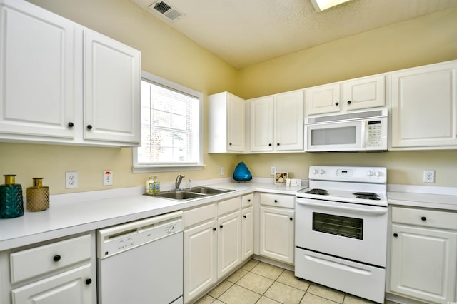 kitchen featuring visible vents, light tile patterned flooring, white appliances, light countertops, and a sink