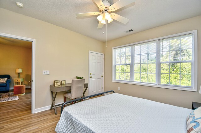 5801 Oyster Catcher Dr Unit 723, North Myrtle Beach, SC 29582 - bedroom featuring light wood-style floors, ceiling fan, a textured ceiling, and connected bathroom