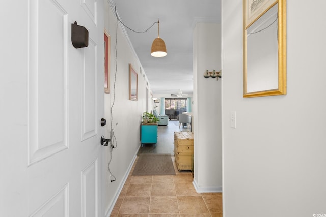 hallway featuring light tile patterned flooring and baseboards