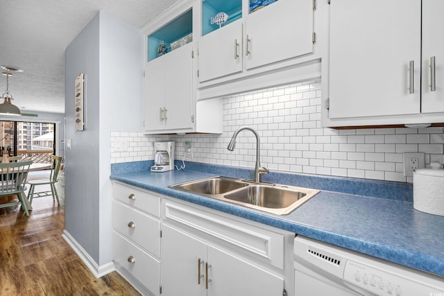 kitchen with dark wood-style floors, white cabinets, a sink, a textured ceiling, and dishwasher